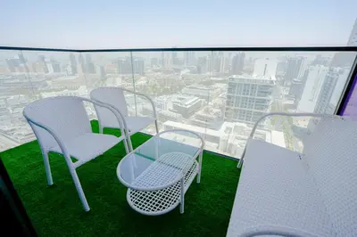 a balcony with chairs and a table on top of a building at Bright 1BR in Binghatti House, Prime Location in Dubai