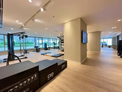a gym with treadmills and a flat screen tv at Elegant and Stylish 1BR, Grand Blue in Dubai