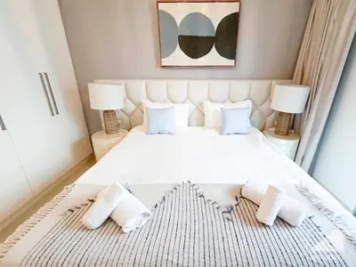 a bedroom with a large white bed with two lamps at Luxurious Burj Crown 2BR Apartment with Balcony in Dubai