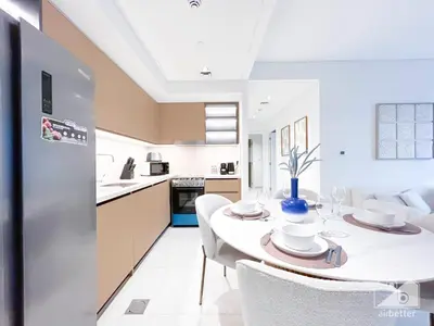 a kitchen and dining room with a white table and chairs at Luxurious Burj Crown 2BR Apartment with Balcony in Dubai
