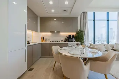 a kitchen and dining room with a table and chairs at TRPS - Azizi Riviera 23, Al Meydan - 2BR Elegant Apartment with Access to Premium Amenities in Dubai