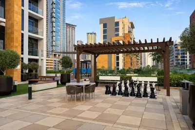a chess board and a giant chess set on a patio at TRPS - Azizi Riviera 23, Al Meydan - 2BR Elegant Apartment with Access to Premium Amenities in Dubai