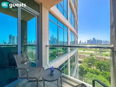 a balcony with two chairs and a table in a building at HiGuests - Luxe 2BR Overlooking Golf Course & Greenery in Dubai