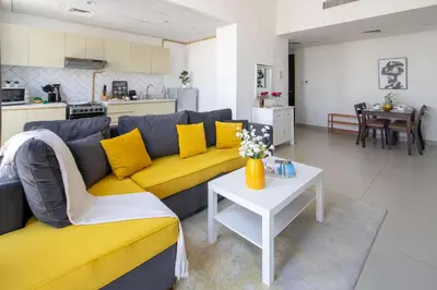 a living room with a yellow couch and a table at Frank Porter - Midtown By Deyaar - Dania 2 in Dubai