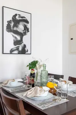 a dining room table with a black and white picture at Frank Porter - Midtown By Deyaar - Dania 2 in Dubai