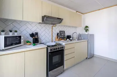 a kitchen with a stove and a microwave at Frank Porter - Midtown By Deyaar - Dania 2 in Dubai