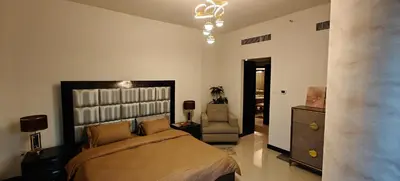 a bedroom with a bed and a chair at JLT 1BR Marina Skyline View in Dubai