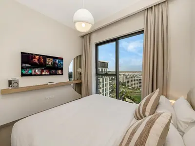 a bedroom with a large bed and a large window at Contemporary Parkfront 2BR Dubai Hills Living in Dubai