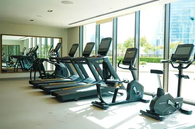 a gym with rows of treadmills and elliptical machines at Full Luxury at Burj Crown 2B with City Views in Dubai