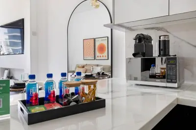 a kitchen with a microwave and a counter with bottles on it at New 1BR with Full Balcony Gym Pool and Sauna in Dubai