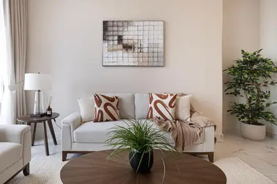 a living room with a couch and a table at 5 Star Amenities 10 Mins Downtown Kite Beach in Dubai