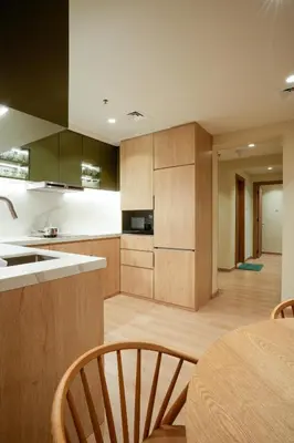 a kitchen with wooden cabinets and a table and chairs at 2 bedroom Apartment Dubai Marina in Dubai