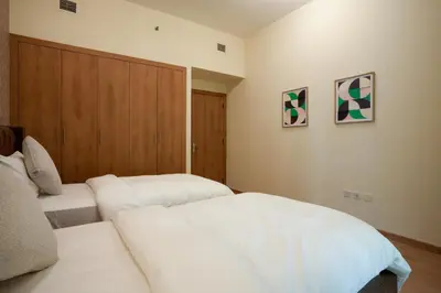 a bedroom with two white beds and a wooden door at 2 bedroom Apartment Dubai Marina in Dubai