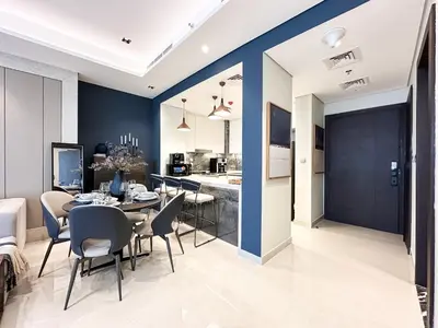 a dining room and kitchen with a table and chairs at Trophy-Luxe Living in a Blue-Hued Haven in Dubai