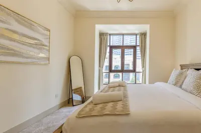 a bedroom with a large bed and a window at Al Tajer Residence, Oldtown - 1BR Apartment - Allsopp & Allsopp in Dubai