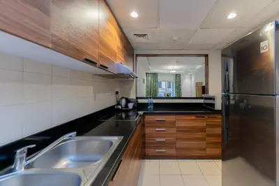 a kitchen with a sink and a stainless steel refrigerator at City Stay Prime Hotel Apartments - Al Barsha in Dubai
