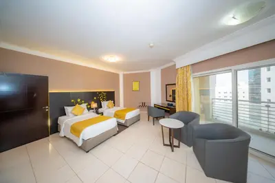 a hotel room with two beds and a desk at City Stay Prime Hotel Apartments - Al Barsha in Dubai
