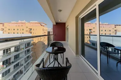 a balcony with a table and a view of a city at City Stay Prime Hotel Apartments - Al Barsha in Dubai