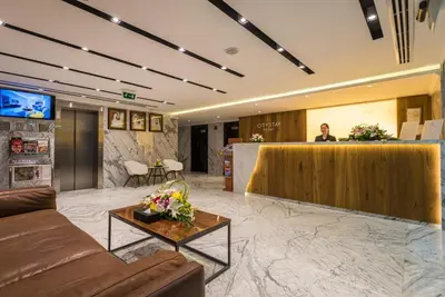 a lobby of a hotel with a woman behind a counter at City Stay Prime Hotel Apartments - Al Barsha in Dubai