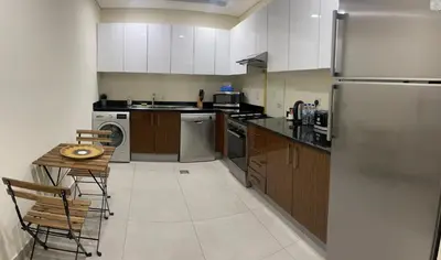 a kitchen with a refrigerator and a table in it at Dubai Marina Sea View hotel Apartment in Dubai