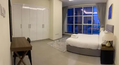 a bedroom with a bed and a window and a desk at Dubai Marina Sea View hotel Apartment in Dubai
