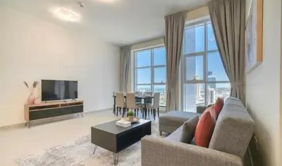 a living room with a couch and a television at Dubai Marina Sea View hotel Apartment in Dubai