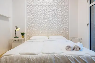 a bedroom with a white bed with towels on it at Retro House in Dubai