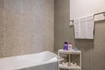 a bathroom with a bath tub and a sink at Retro House in Dubai