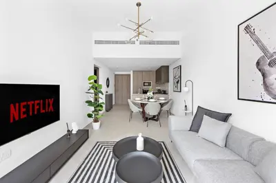 a living room with a couch and a table at Vayk - Modern 2BR with Private Plunge Pool in JVC in Dubai