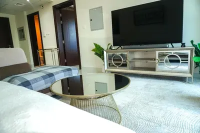 a living room with a television and a coffee table at Stylish 1BR in Elite 7 Sports City in Dubai