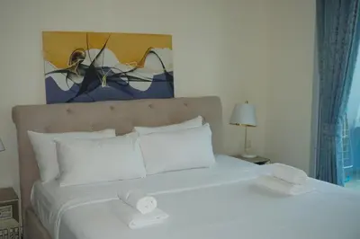 a white bed with two towels on top of it at Stylish 1BR in Elite 7 Sports City in Dubai