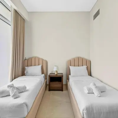 a bedroom with two beds and a nightstand between them at Luxury Canal View-2BR Maid's Room in CF 2, Al Wasl in Dubai