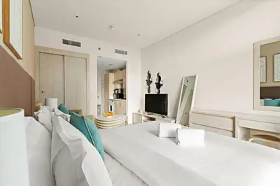 a living room with a white couch and a television at FIRST CLASS Studio Palm Paradise in Dubai