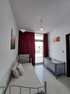 a bedroom with a bed and a window with red curtains at Damac Hills 2- 3BR Townhouse - Homeyvillas in Dubai