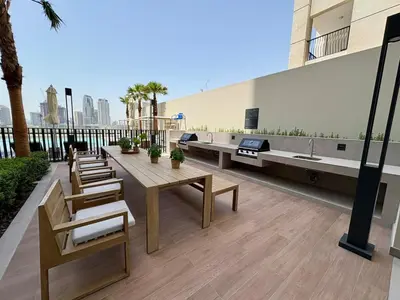 a patio with a table and chairs and a sink at Stylish Studio in JVC with Pool, Gym, Balcony & Modern Comforts in Dubai