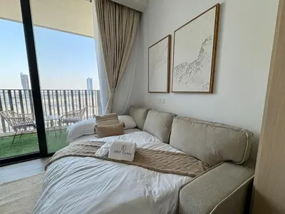 a living room with a couch and a large window at FIRST CLASS Studio Unwind in Style in Dubai