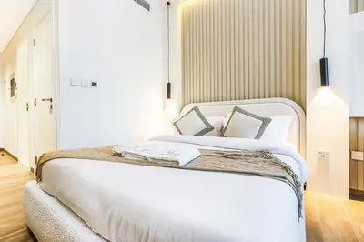 a bedroom with a large bed with white sheets and pillows at FIRST CLASS Studio Unwind in Style in Dubai