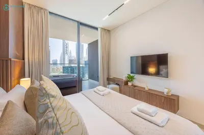 a bedroom with a large bed and a television at Blue Breeze - Luxurious 1BR with Private Jacuzzi & Burj View in Dubai
