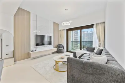 a living room with a couch and a tv at Act tower-1BR near Burj Khalifa in Dubai
