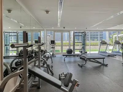 a gym with several treadmills and machines in a building at Modern 1 Bed with Burj View From Balcony & Pool and Gym Access in Dubai