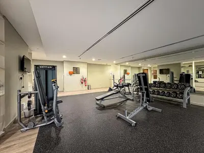 a gym with several treadmills and cardio machines at Modern 1 Bed with Burj View From Balcony & Pool and Gym Access in Dubai