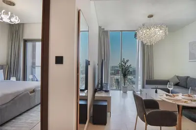 a bedroom with a bed and a living room with a mirror at EasyGo-Modern, Distinguished with Sofa Bed in Dubai