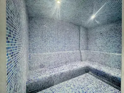 a bathroom with white tiled walls and a tub at GuestReady - Luxe waterfront stay in Dubai Marina in Dubai