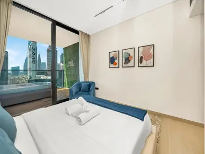 a bedroom with a white bed and a large window at Chic 1BR Burj Khalifa Views Private Jacuzzi in Dubai