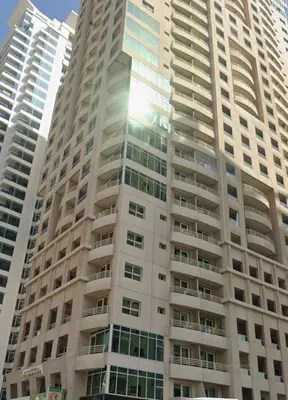 a tall building with the sun reflecting off of it at The Manchester JBR Marina Apartment Private Room with shared washroom in Dubai