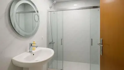 a bathroom with a sink and a shower with a mirror at The Manchester JBR Marina Apartment Private Room with shared washroom in Dubai