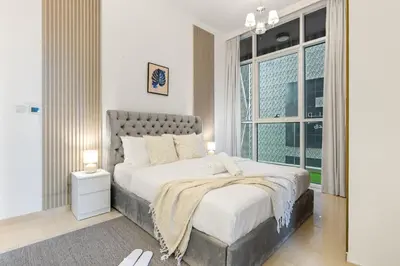 a bedroom with a large bed and a window at Luxury 1 BR - Walk to Dubai Mall & Burj Khalifa in Dubai