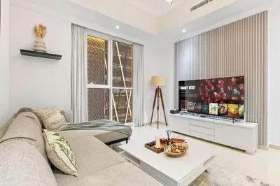 a living room with a couch and a tv at Luxury 1 BR - Walk to Dubai Mall & Burj Khalifa in Dubai