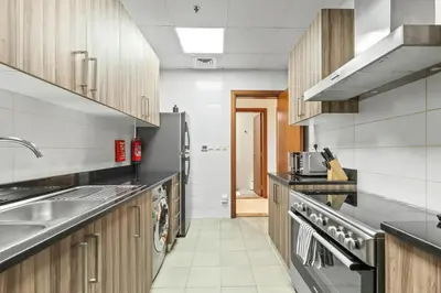 a kitchen with a sink and a refrigerator at Luxury 1 BR - Walk to Dubai Mall & Burj Khalifa in Dubai