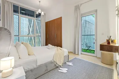 a living room with a white couch and a large window at Luxury 1 BR - Walk to Dubai Mall & Burj Khalifa in Dubai